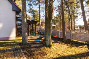 a yard with trees and a house with a playground at Apartment with Veranda Toruńska Pobierowo by Renters in Pobierowo