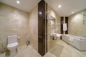 a bathroom with a toilet and a tub and a sink at Rosslyn Dimyat Hotel Varna in Varna City