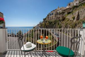 a table and chairs on a balcony with a view of the ocean at Casa Carmela in Positano