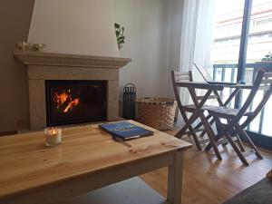 a living room with a table and a fireplace at Casa Naseiro in Melide