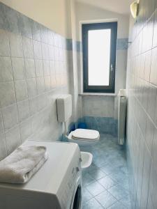 a bathroom with a bed and a toilet and a window at Soggiorno con splendida vista in Monforte dʼAlba