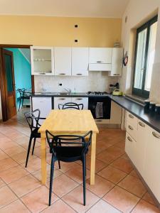 cocina con mesa de madera y sillas en Soggiorno con splendida vista, en Monforte dʼAlba