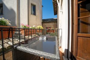 a glass table on the balcony of a building at Affittacamere Valentina in Orvieto
