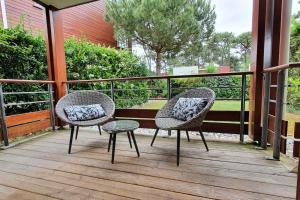 twee stoelen en een tafel op een veranda bij Résidence Escale Océane T2 42 m2 à 500 m de la Plage in Capbreton