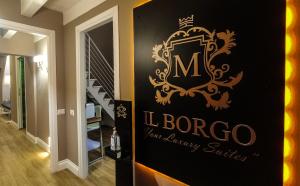 a sign for a luxury house with a sign for a staircase at Il Borgo Your Luxury Suites in Nettuno