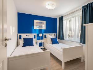two beds in a room with blue walls at Beliebte Ferienwohnungen in Flensburg in Flensburg