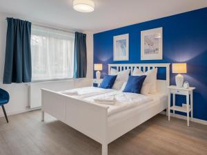 a bedroom with a white bed with blue walls at Beliebte Ferienwohnungen in Flensburg in Flensburg