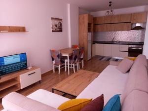 un soggiorno con divano e tavolo e una cucina di Sea View Mario's Apartment a Sakës