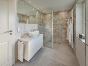 een badkamer met een witte wastafel en een douche bij Ferienwohnung Flensburg in Flensburg