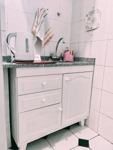 uma cozinha branca com um lavatório e um balcão em Departamentos PLENO CENTRO em Tupungato
