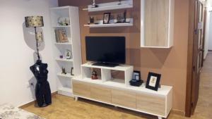 a living room with a television on a white entertainment center at LA POSAINA in Serradilla