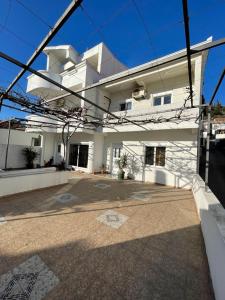 a white house with a courtyard in front of it at Apartmani centar ulcinj in Ulcinj
