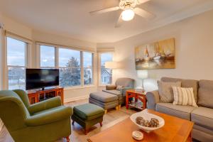 a living room with a couch and a tv at Manistee Retreat with Pool Access, Walk to Beach! in Manistee