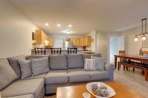 a living room and kitchen with a couch and a table at Manistee Retreat with Pool Access, Walk to Beach! in Manistee