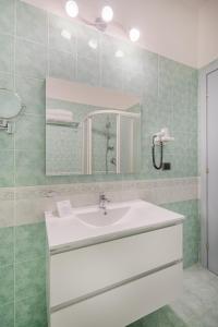a bathroom with a white sink and a mirror at Hotel La Baja in Santa Caterina