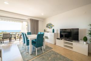 - un salon avec une table à manger et une télévision dans l'établissement BeGuest Aveiros Beach View Apartment, à Albufeira