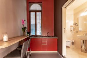 a bathroom with a sink and a red wall at Residenza Manin Apartments in Venice