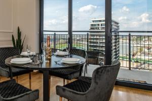 a dining room with a table and chairs and a balcony at Luxury Stay in Belgrade Waterfront with Views in Belgrade