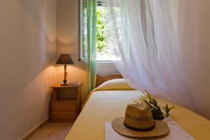 a hat sitting on a bed with a window at Casa Paleopolis in Corfu Town