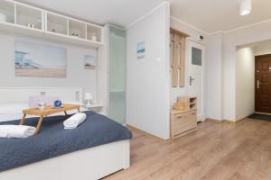 a bedroom with a bed and a wooden table at Śródmieście Gdynia Studio Zygmunta Augusta by Renters in Gdynia