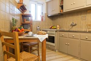 una cocina con una mesa con un bol de fruta. en Casa Paleopolis en Corfú