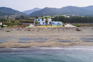 Blick auf einen Strand mit einem Haus und das Meer in der Unterkunft Seafront Villa Sea Gem - Private Beach Area & Infinity Pool in Polis Chrysochous