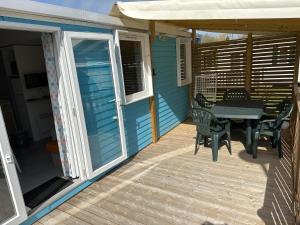 a patio with a table and chairs on a house at mobil home 6 places tout confort in Saint-Georges-de-Didonne