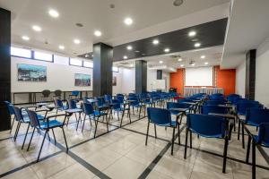 a conference room with blue chairs and a podium at Hotel Relax in Siracusa