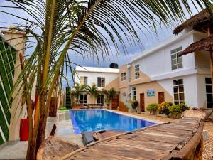 a swimming pool in front of a house with a palm tree at VICK Boutique Hotel with New power backup in Banda Kuu