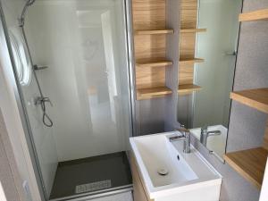 y baño con lavabo y ducha. en mobil home 6 places tout confort, en Saint-Georges-de-Didonne