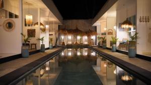 a swimming pool in a building with potted plants at The White Bay in Gili Trawangan