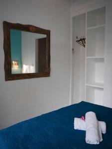 a bedroom with a mirror and two towels on a bed at The White Bay in Gili Trawangan