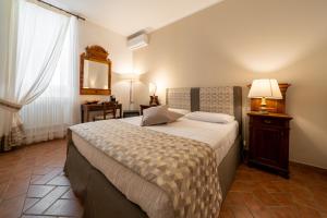 una camera con un grande letto e uno specchio di Affittacamere Valentina a Orvieto