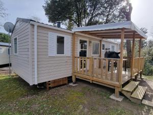 a tiny house with a porch and a gazebo at Beau Mobil home 64 in Saint-Jean-de-Monts