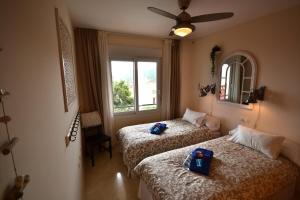 una camera da letto con due letti e una finestra di Manilva Playa 15C a Manilva