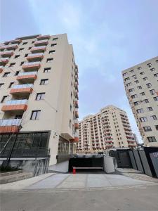 two tall white buildings in a city with a street at UpTown Apartments in Iaşi
