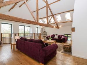 a living room with two couches and a table at Owl Barn in Leominster