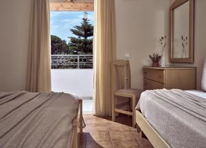 um quarto com uma cama e vista para uma varanda em Windmill Hotel em Argasi