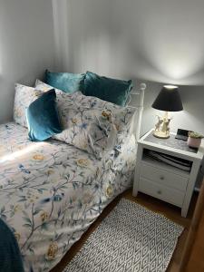 a bedroom with a bed and a night stand with a lamp at Kabin in the woods with Hot Tub in Llandybie