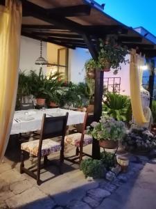 un tavolo e sedie in un patio con piante di Trulli la casa di Rosa ad Alberobello