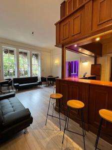 uma sala de estar com um bar e alguns bancos em The Beeches - Entire Mansion em Bristol