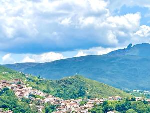 a town on a hill with mountains in the background at Casa charmosa no Centro Histórico com garagem in Ouro Preto