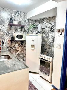 a kitchen with a white refrigerator and a stove at Casa charmosa no Centro Histórico com garagem in Ouro Preto