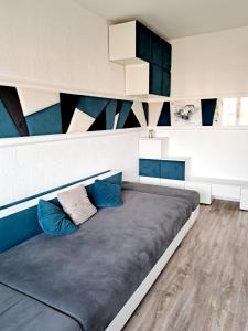 ein großes Bett mit blauen Kissen in einem Zimmer in der Unterkunft Garsonieră modernă-Zona Micalaca in Arad