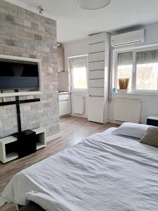 ein Schlafzimmer mit einem großen Bett und einer Ziegelwand in der Unterkunft Garsonieră modernă-Zona Micalaca in Arad