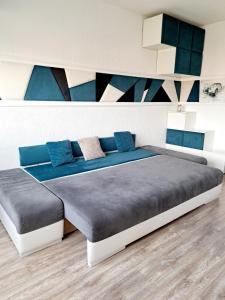 ein Schlafzimmer mit einem großen Bett mit blauen Kissen in der Unterkunft Garsonieră modernă-Zona Micalaca in Arad