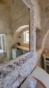 a mirror on a stone wall in a room at Casa Relax Isabelle in Alberobello
