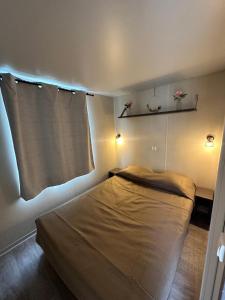 a small bedroom with a bed with lights on it at Au p’tit bonheur in La Roque-dʼAnthéron