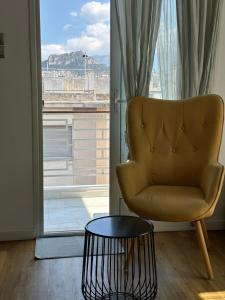 una silla y una mesa frente a una ventana en Vasilis luxury apartment en Athens