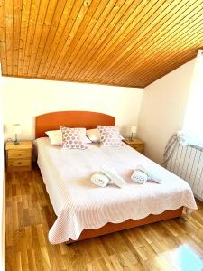 - une chambre avec un grand lit et un plafond en bois dans l'établissement Apartments Toni, à Podstrana